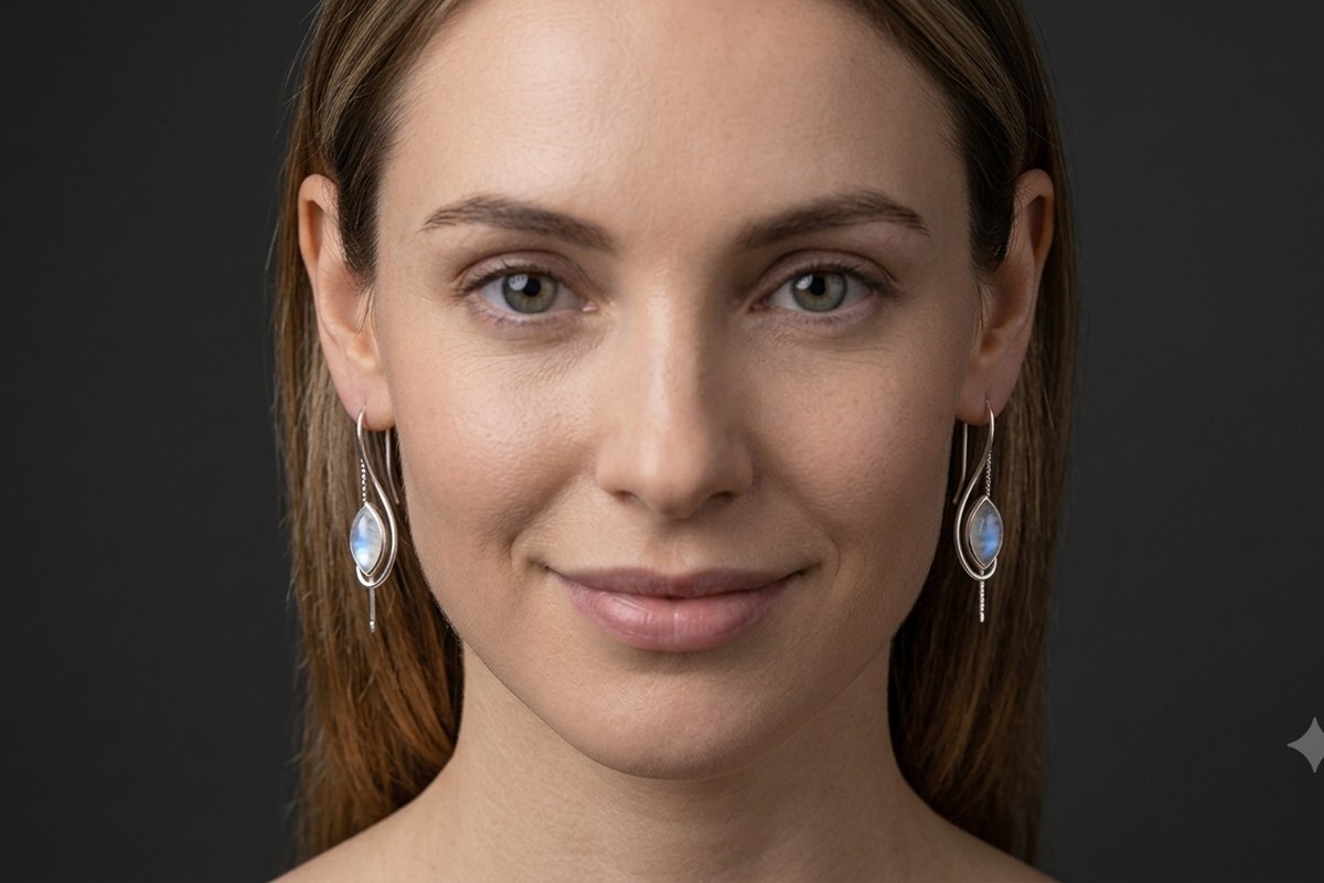 A woman wearing marquise rainbow moonstone drop earrings in 925 sterling silver